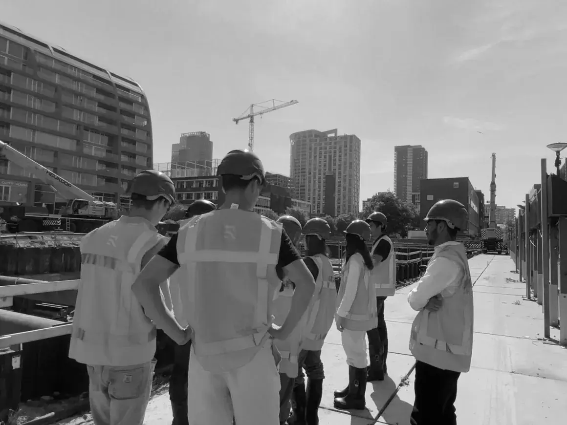 Members in hard hats on a construction site visit