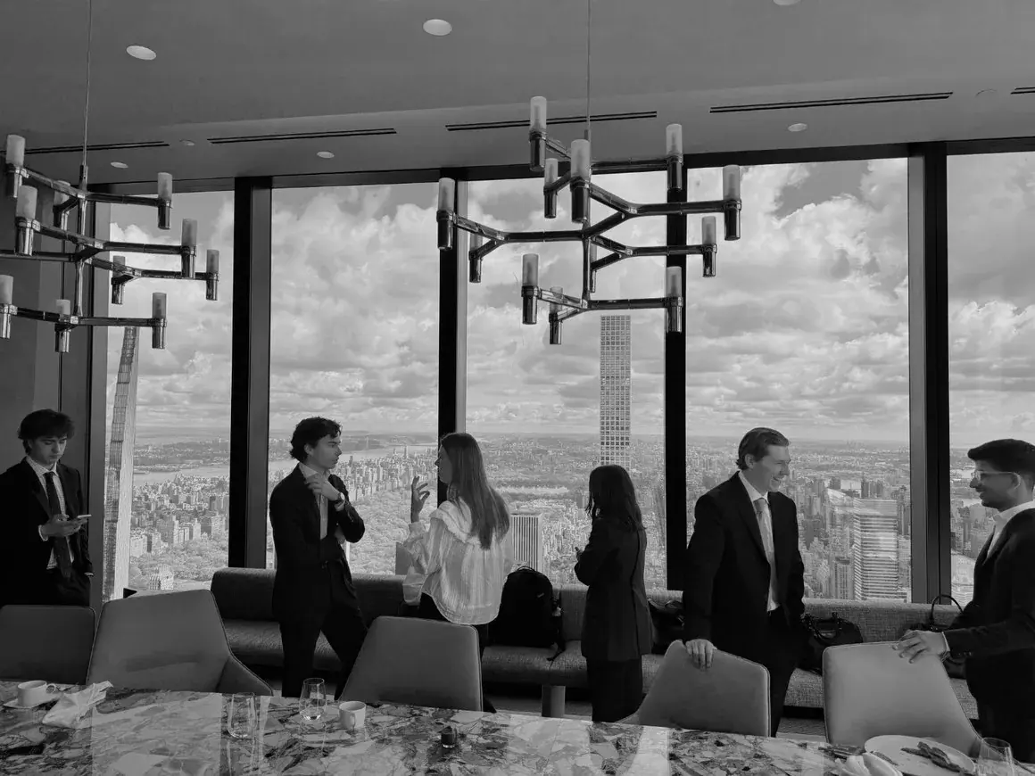 Members talking in a top-floor lounge above the city
