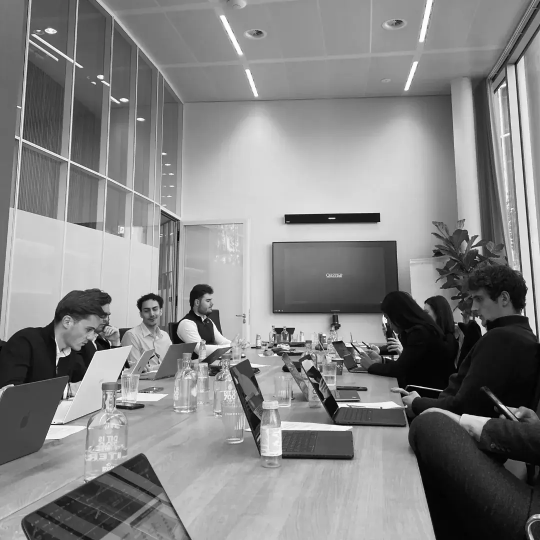 A team working through a case challenge around a boardroom table
