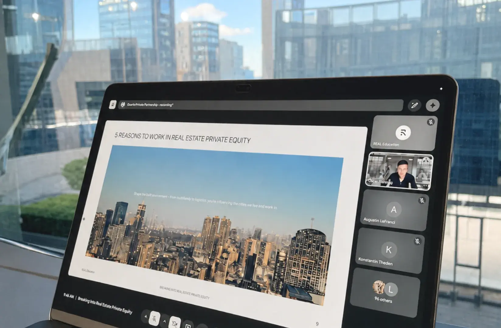 A webinar running on a tablet in front of a city skyline